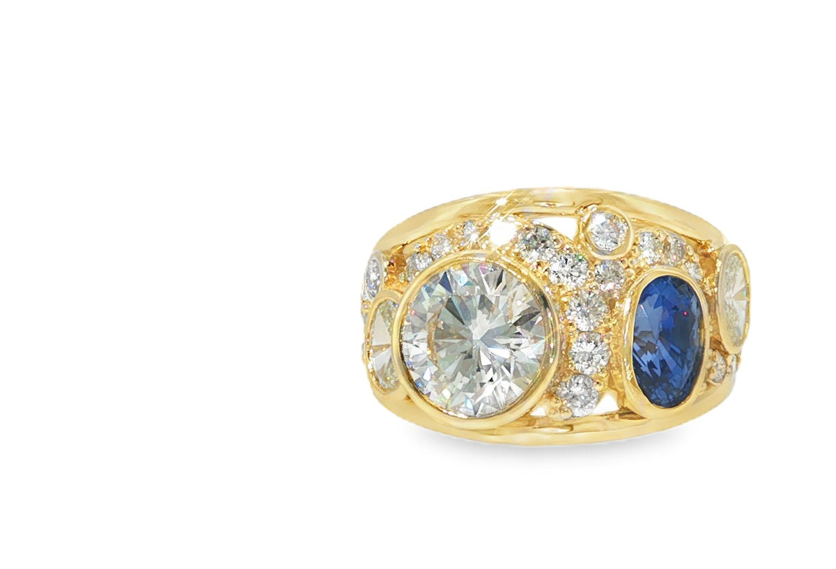 After: the gold and stones remade into a custom yellow gold ring with a round diamond, an oval blue sapphire and pavé diamonds