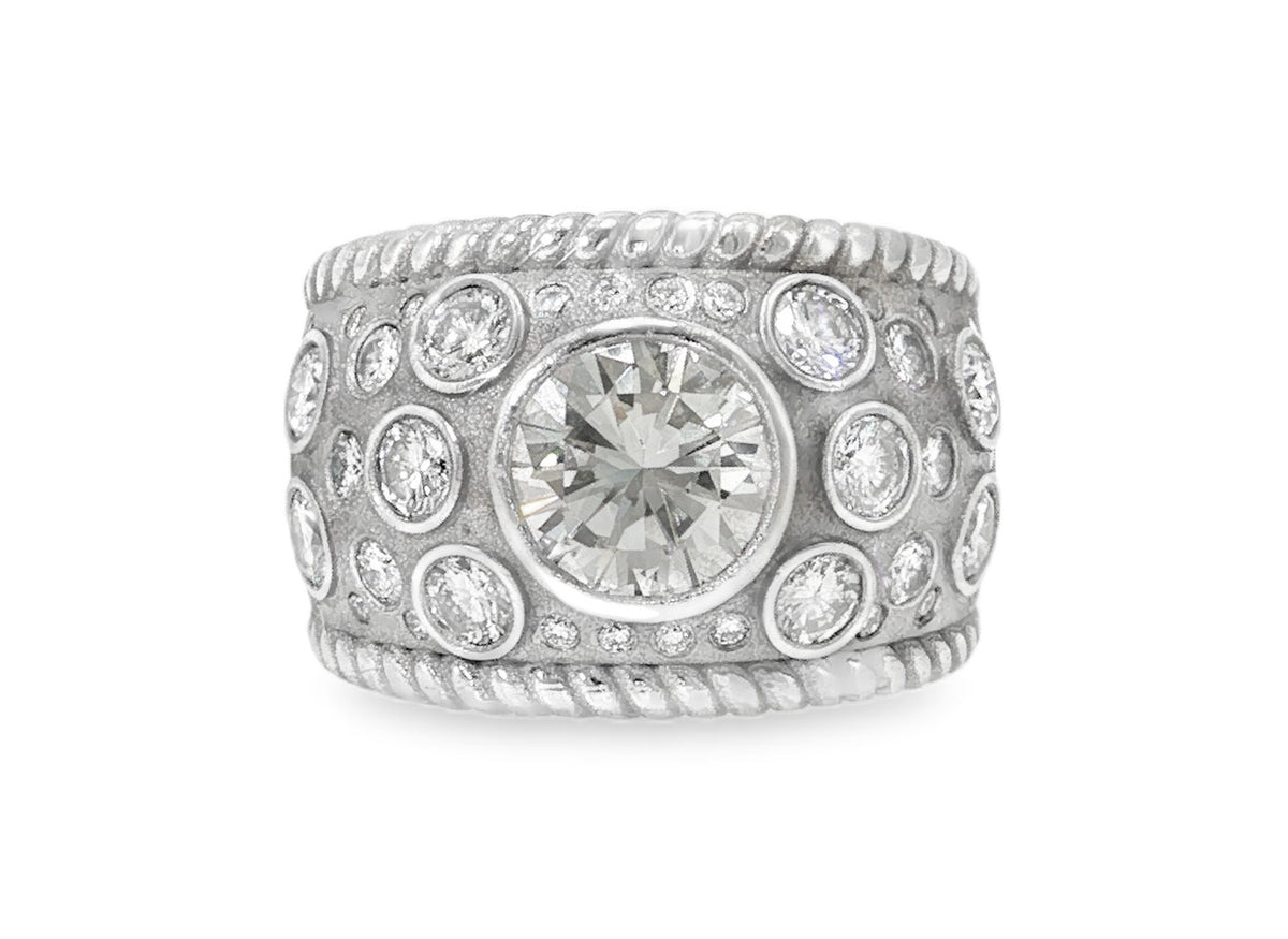 After: the diamonds reset into one custom white gold band with a large bezel-set center diamond and rope-twist edges